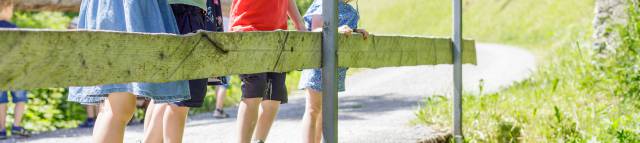 Kinder stehen auf einer Brücke und schauen runter