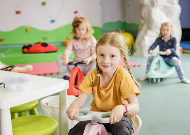 Children sitting on bobby cars