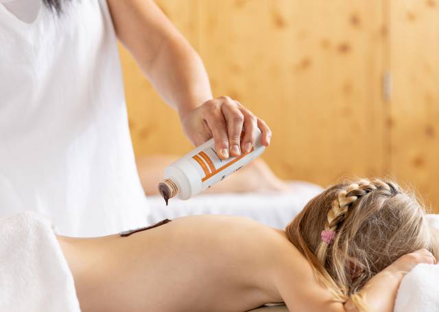 Kind bekommt Schokoladen-Massage im Familotel Kaiserhof in Tirol