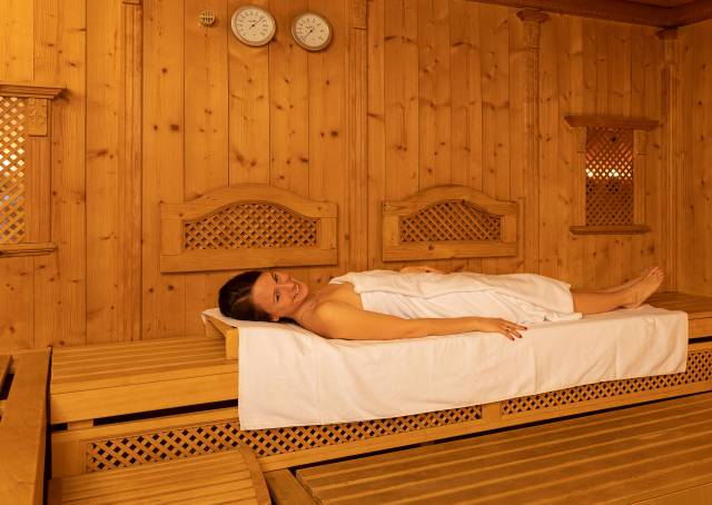 Frau liegt in einer Holzsauna im Wellnesshotel Kaiserhof