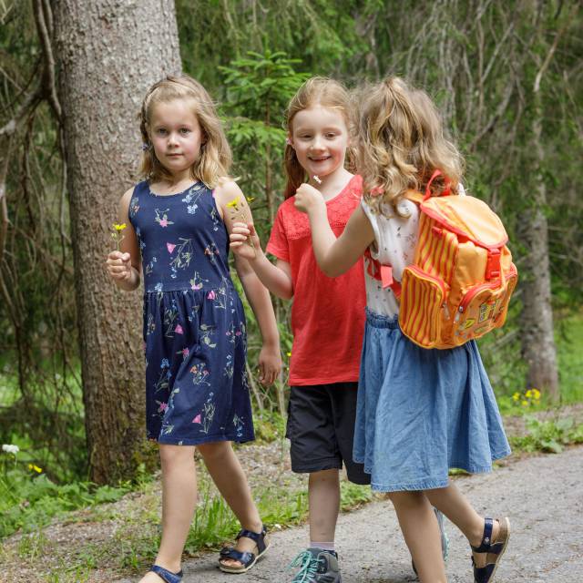 Three girls walk along the street