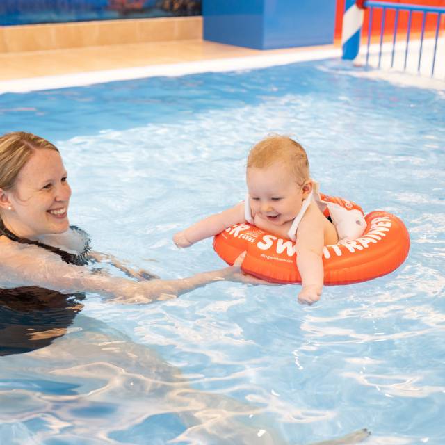 Mutter mit Baby beim Babyschwimmen im Pool