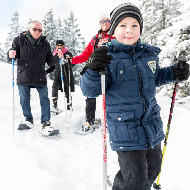 Family with child and grandparents snowshoeing in Tyrol