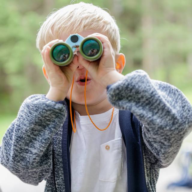 Junge schaut durch das Fernglas