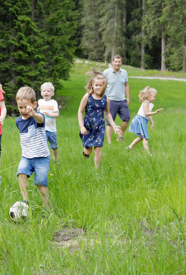 Children playing soccer on a green field