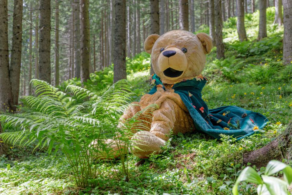Familotel Kaiserhof mascot Bärtram sits in the forest