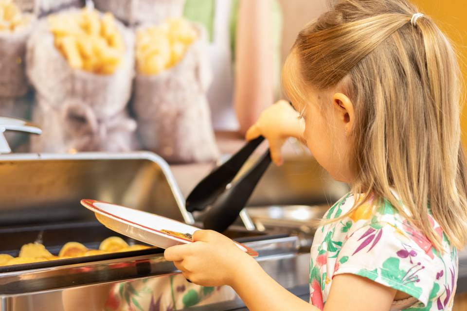 Child getting food at the kids' buffet at the Familotel Kaiserhof in Tyrol.