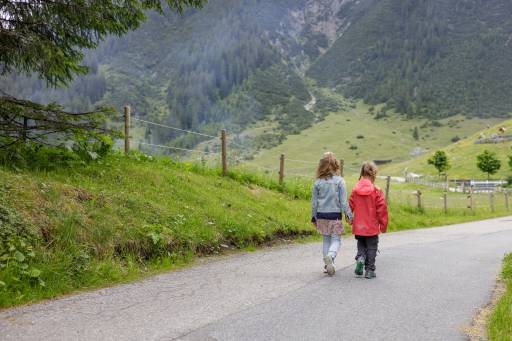 Kinder laufen Straße herunter in Berwang