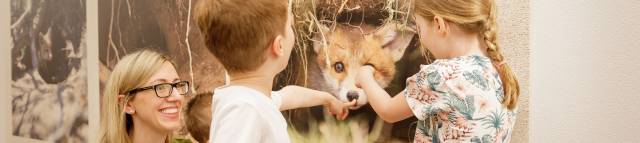 Kinder stehen vor einer Wand mit Fuchsbildern