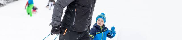 Eltern und Kinder spielen im Schnee in Berwang