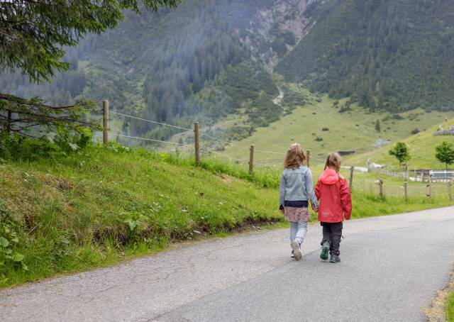 Kinder laufen Straße herunter in Berwang