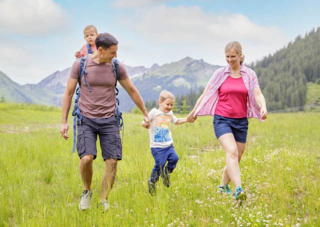 Familie spaziert über Wiese in Bergwang, Tirol
