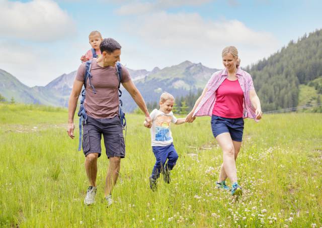 Familie läuft über Wiese in Tirol