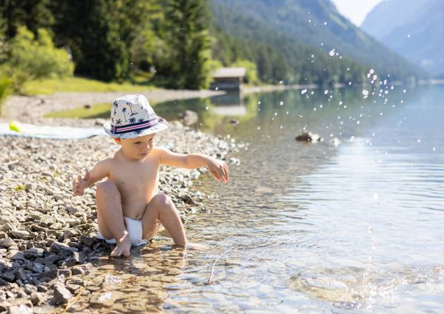 Junge spielt im Heiterwanger See im Sommer