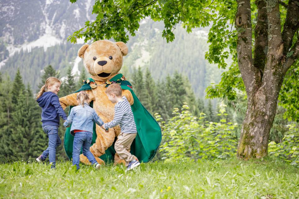 Familotel Kaiserhof Maskottchen spielt mit Kindern auf einer Wiese