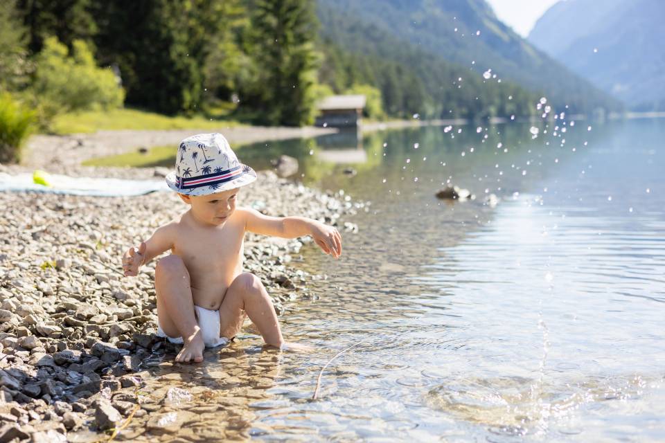 Junge spielt im Heiterwanger See im Sommer