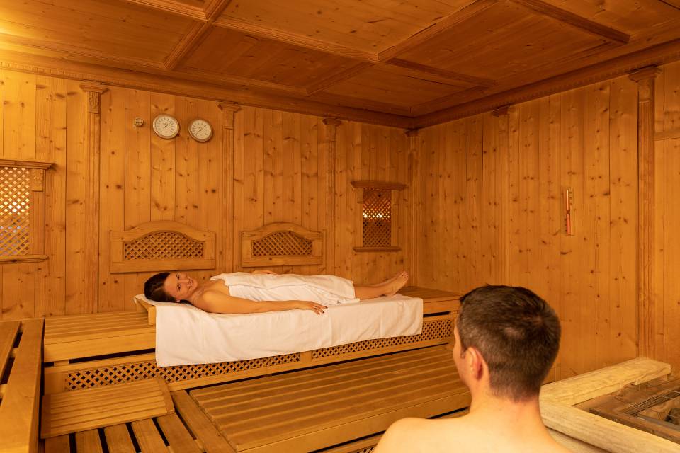 Pair in a wooden sauna at Hotel Kaiserhof's wellness resort.