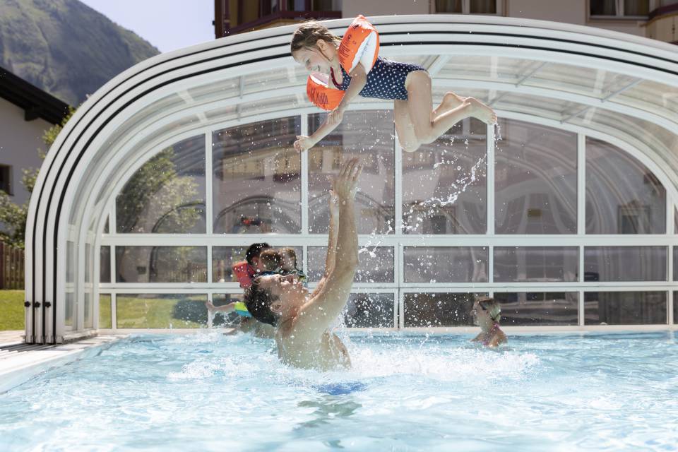 Father tosses daughter in the pool into the air
