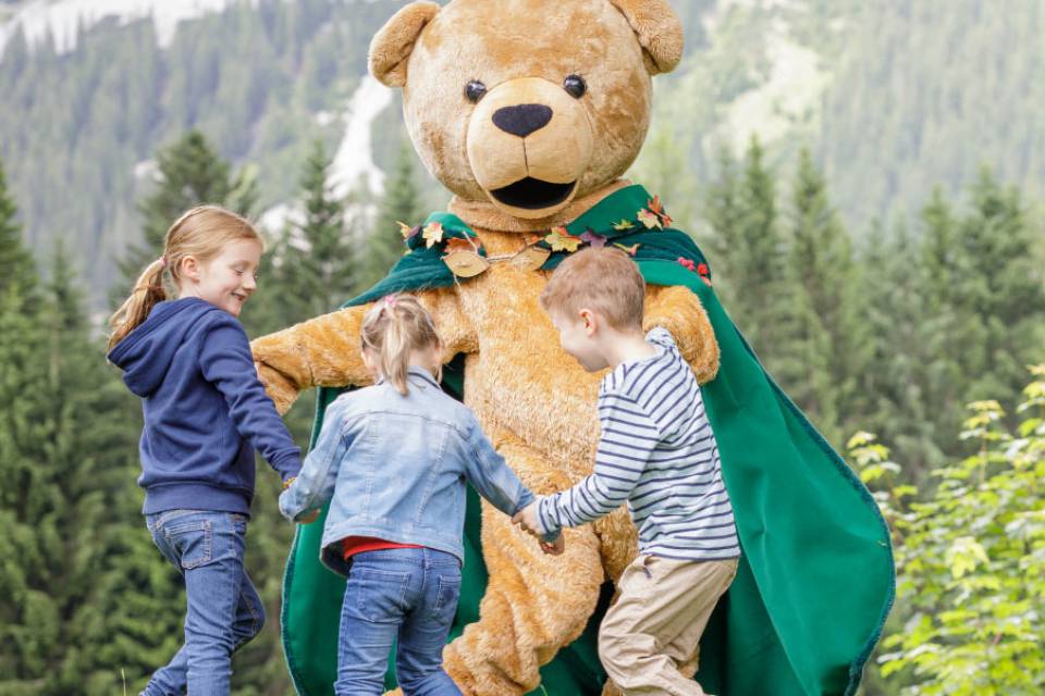 Familotel Kaiserhof Maskottchen spielt mit Kindern auf einer Wiese