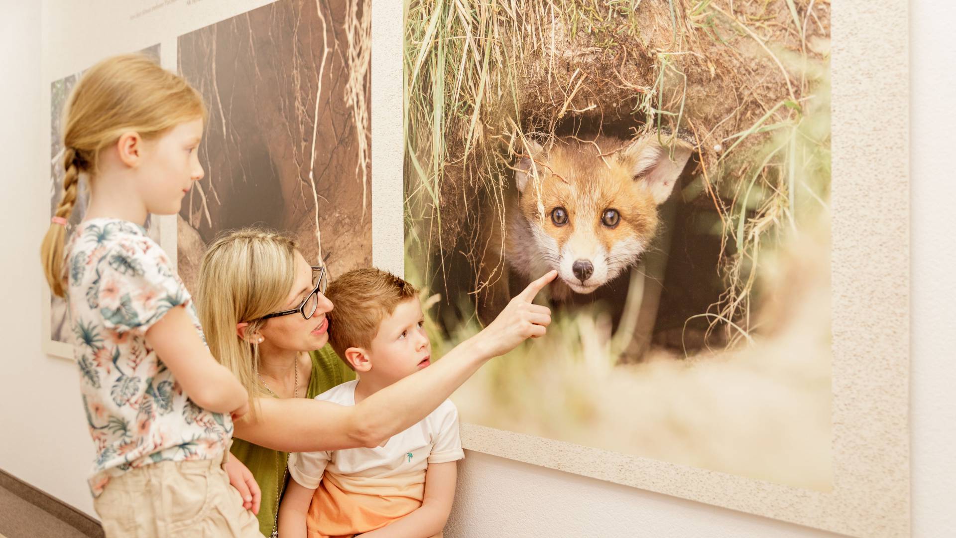 Mutter und Kinder stehen vor Fuchsbild