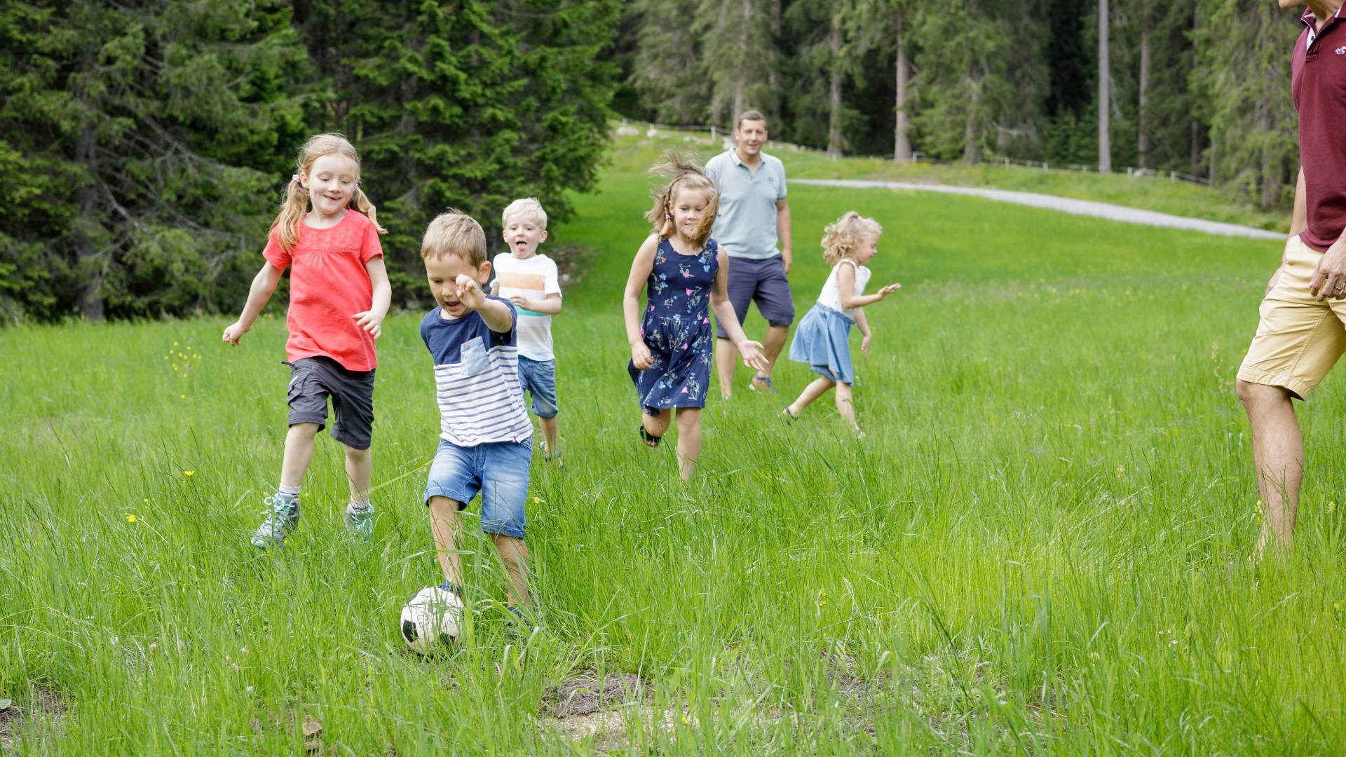 Children playing soccer on a green field