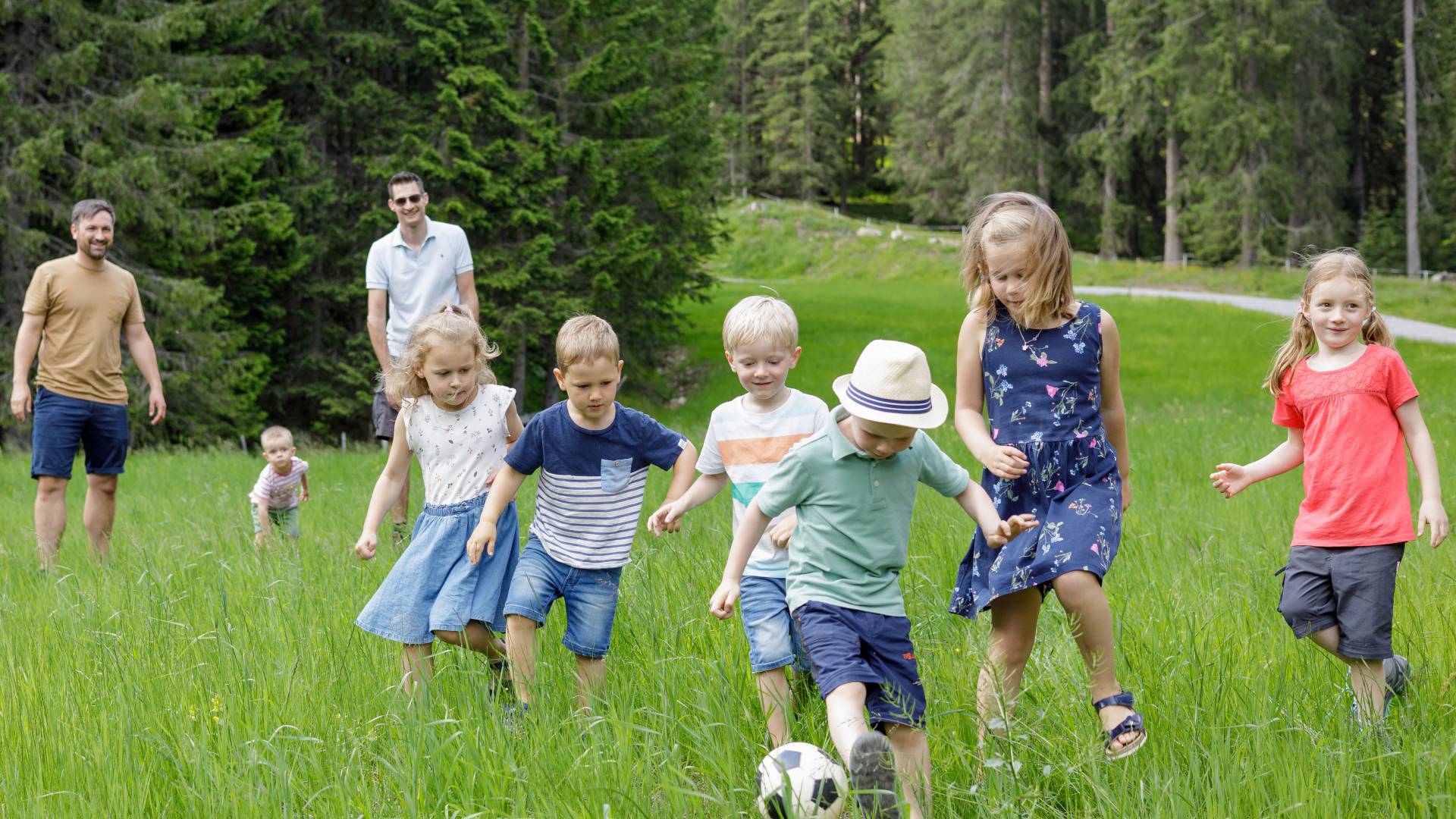 Kinder spielen Fußball auf einer Wiese