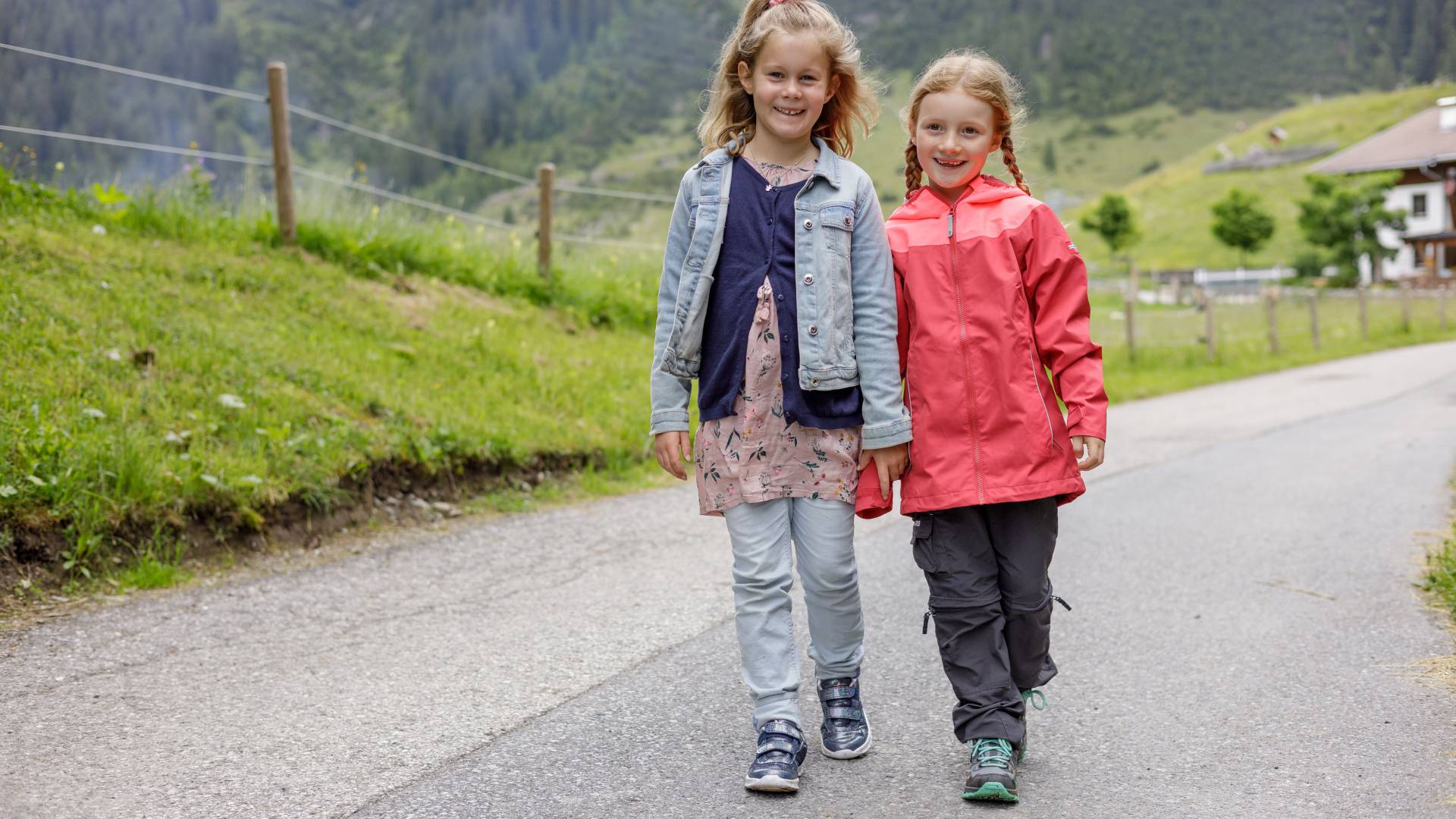 Mädchen laufen eine Straße herunter entlang Wiesen