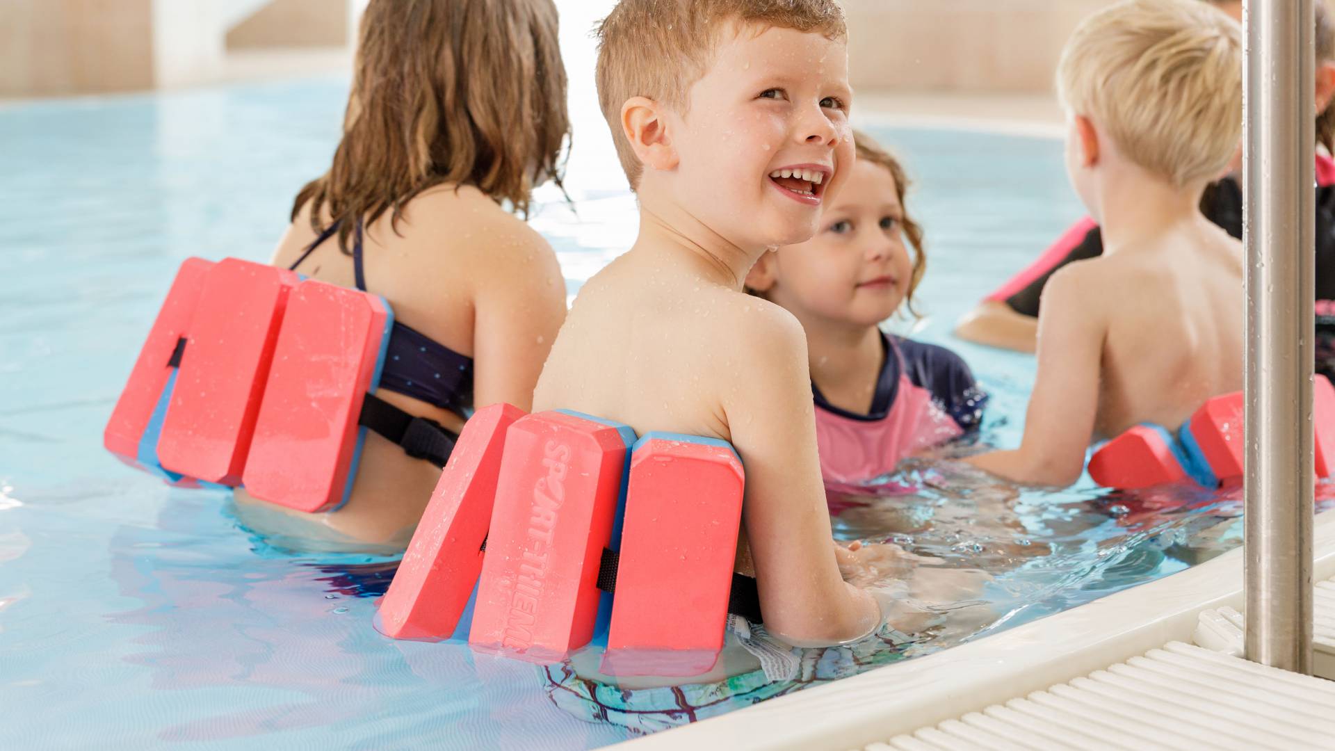 Kinder mit Schwimmhilfen im Wasser des Familotel Kaiserhof in Tirol