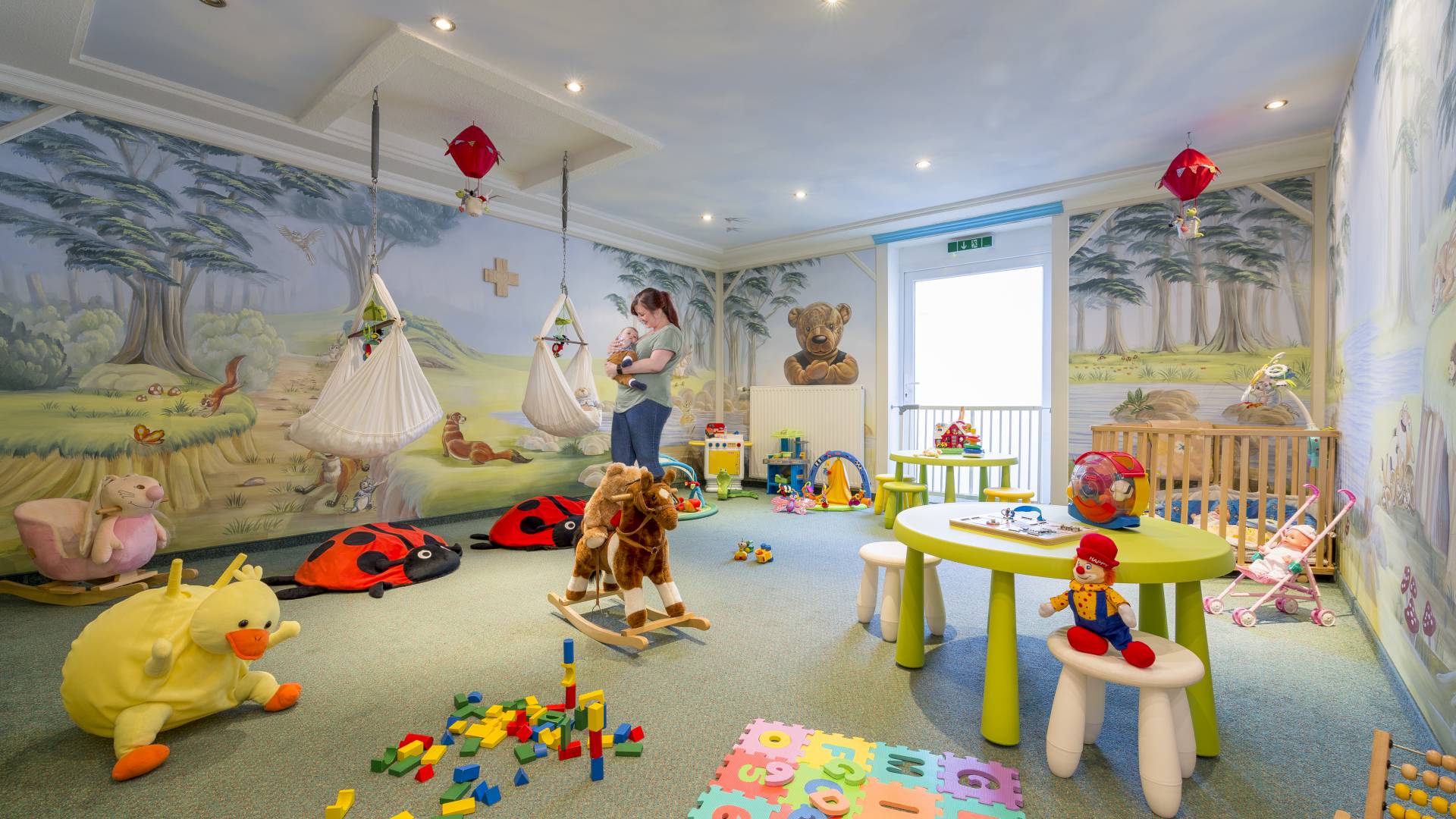 Mother has child in her arms in the playroom